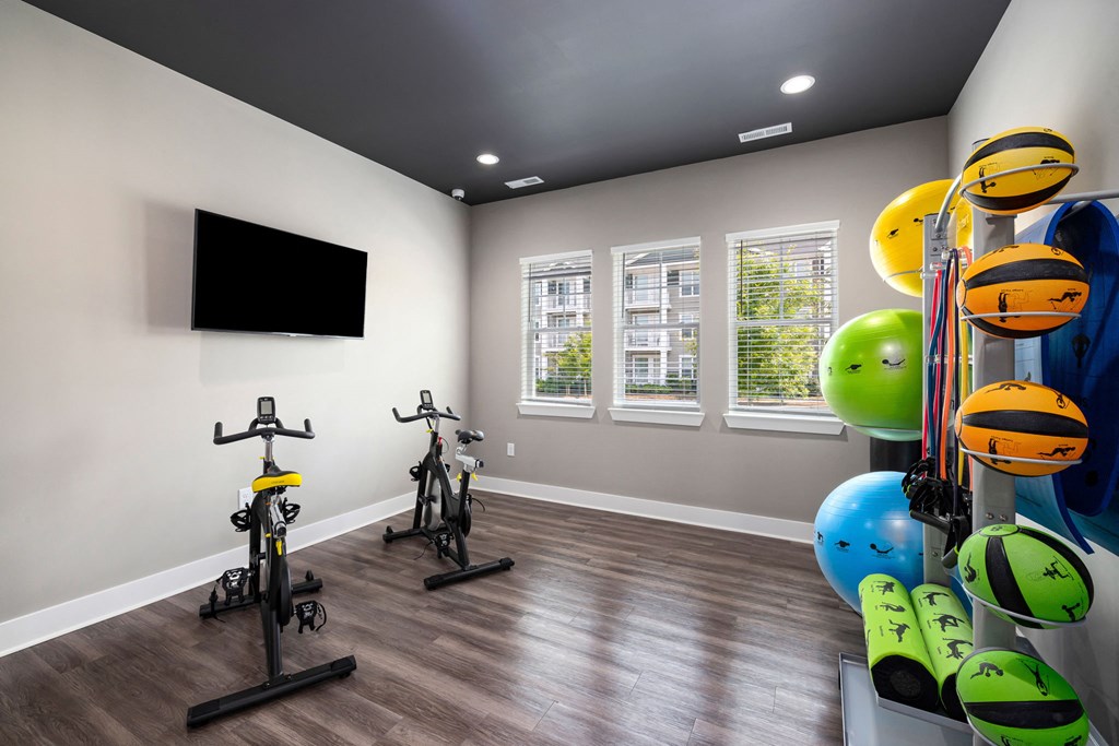 a home gym with exercise equipment and a flat screen tv