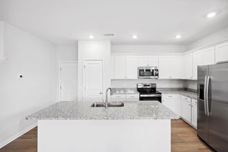 a white kitchen with granite counter tops and stainless steel appliances