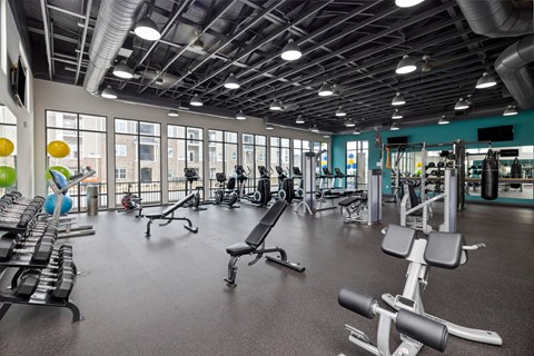 A gym with a variety of equipment including treadmills, weights, and exercise machines.