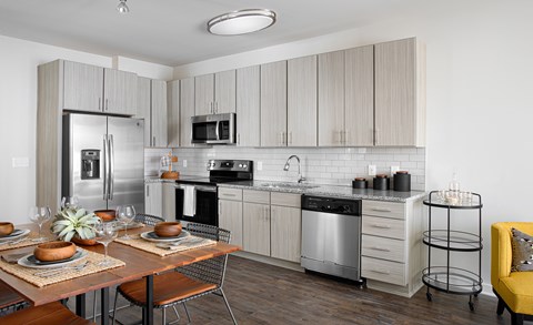 A modern kitchen with a dining table set for two.
