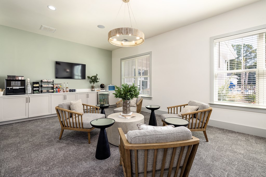 a living room with chairs and a table and a television