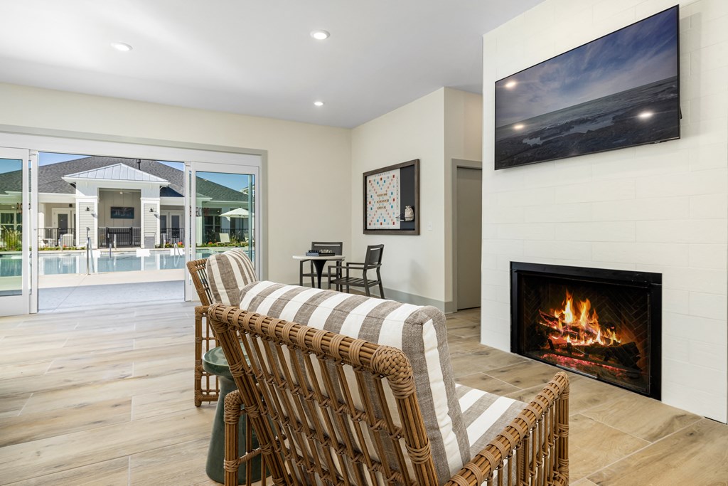 the living room has a fireplace and a view of the pool