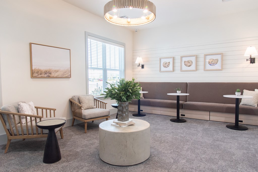 a living room with couches chairs and tables and a chandelier