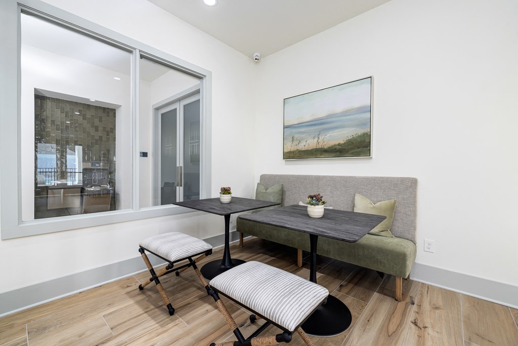 a living room with a couch and a table with two chairs and a large window