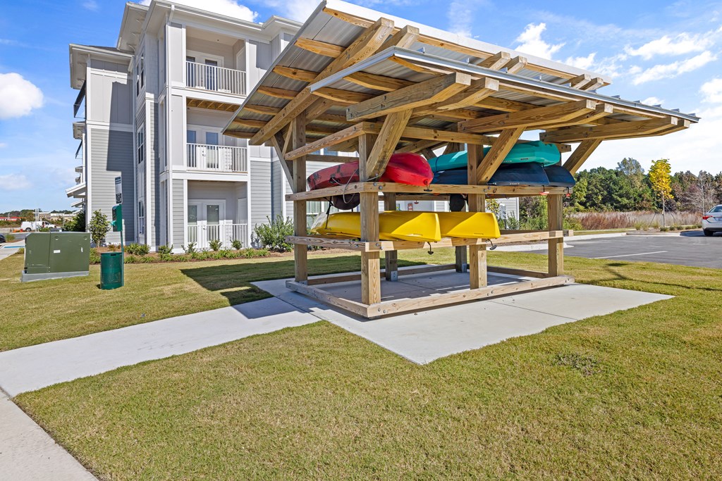 a picnic table with colorful kayaks on it in front of a building