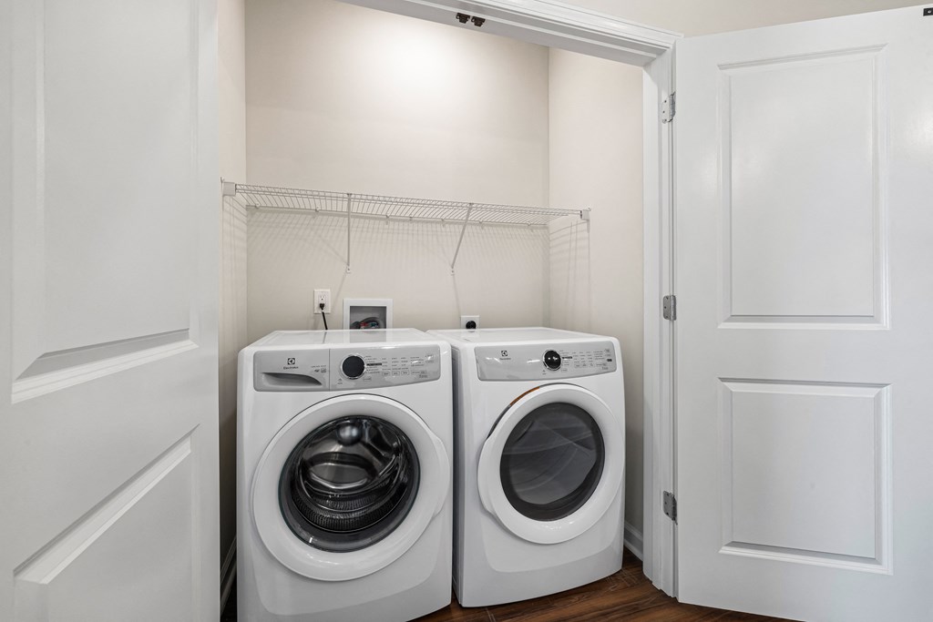 a washer and dryer in a laundry room with a white door
