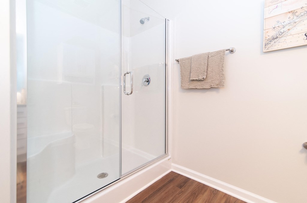 a shower with a glass door in a white bathroom