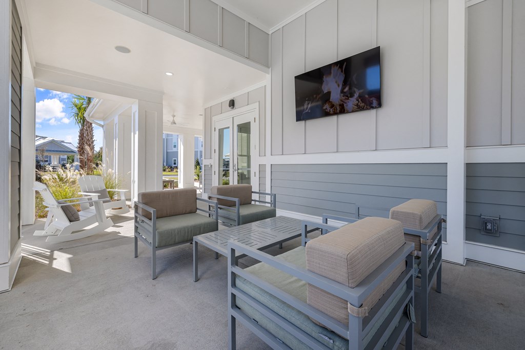 a patio with a table and chairs and a tv on the wall
