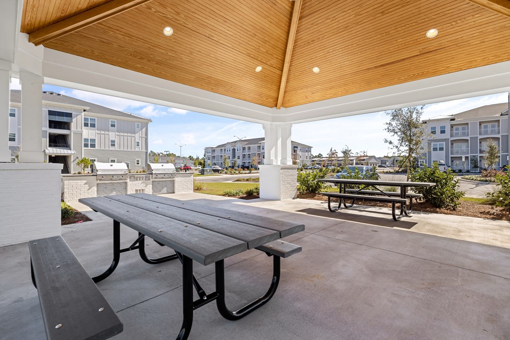 two picnic tables on a patio with a building in the background
