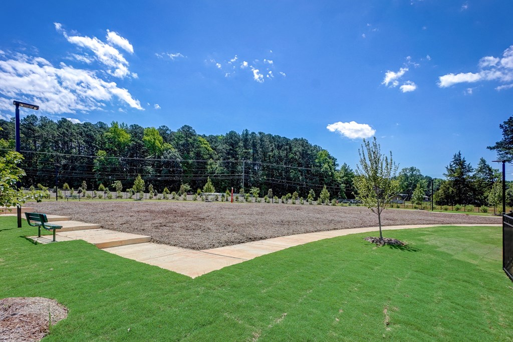 a garden with a dirt field and a bench