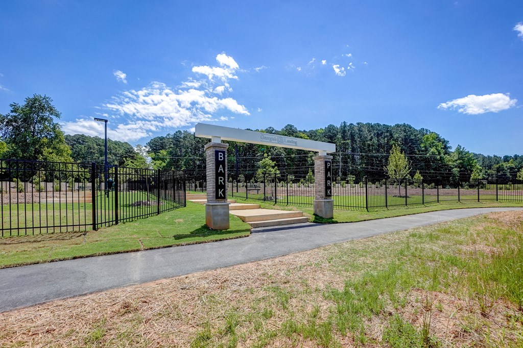 the entrance to a park with a black fence and a gate