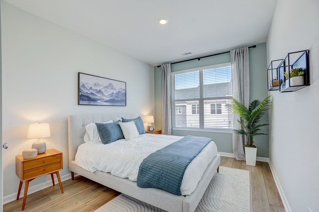 a bedroom with a bed and a large window