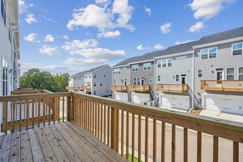 the deck of an apartment building with a view of neighboring units