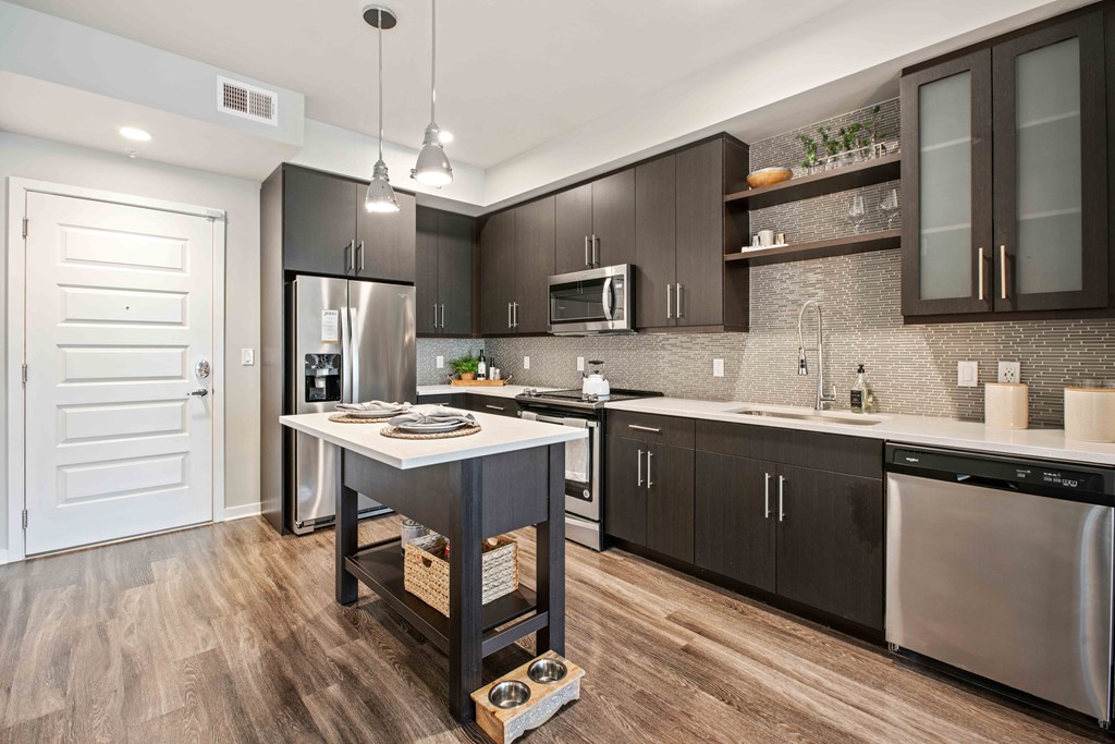 A modern kitchen with dark brown cabinets and stainless steel appliances.
