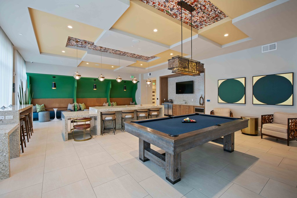 A room with a pool table and a television.