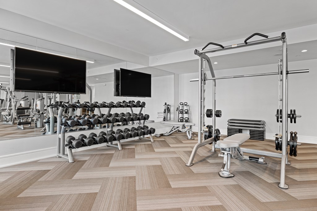 A gym with a variety of equipment including a bench press.