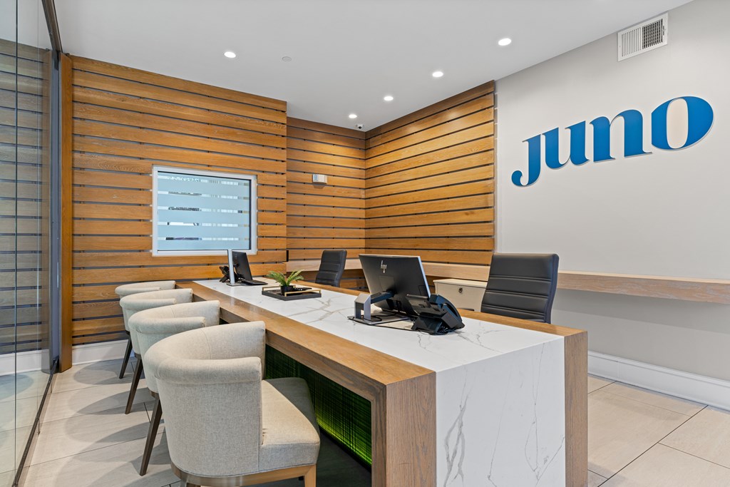 A Jumo logo is on a wall above a desk with chairs.