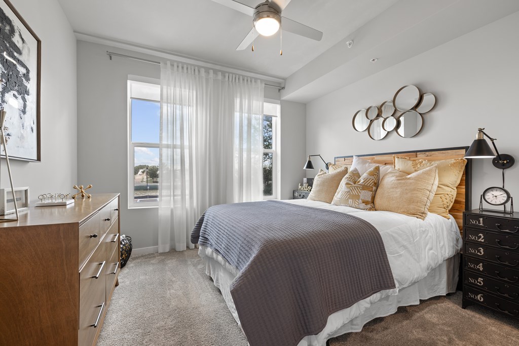A bedroom with a large bed and a ceiling fan.