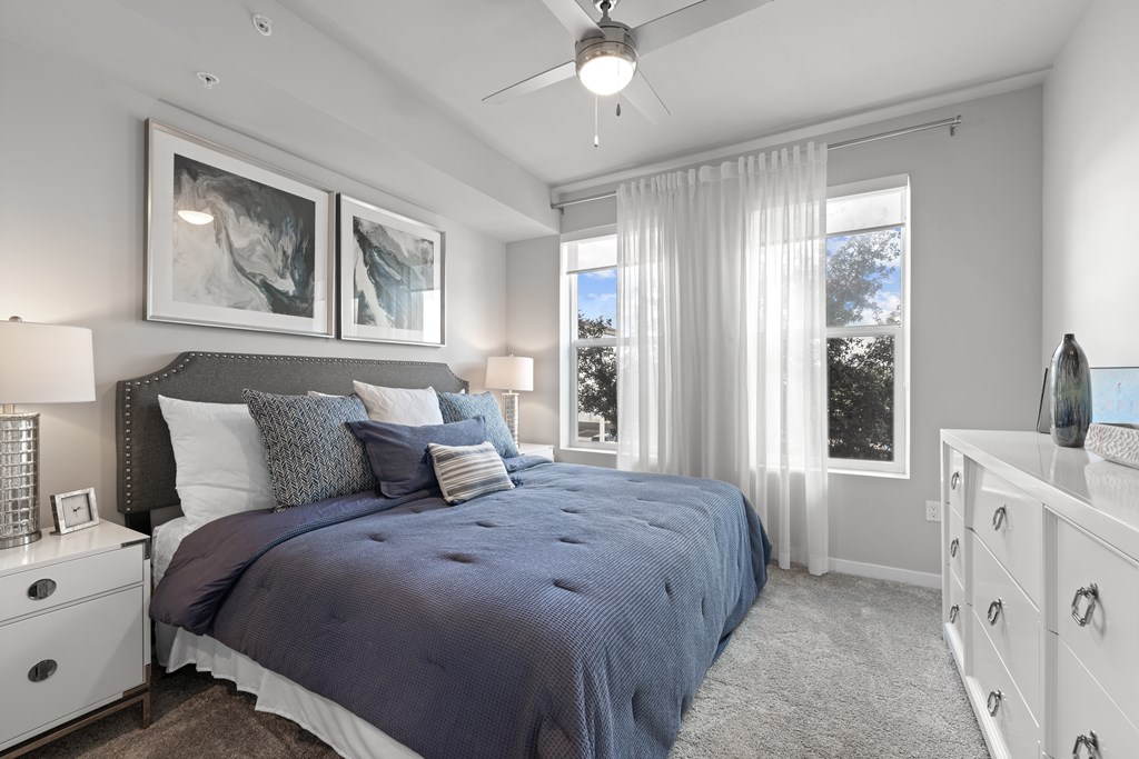A bedroom with a large bed and a ceiling fan.