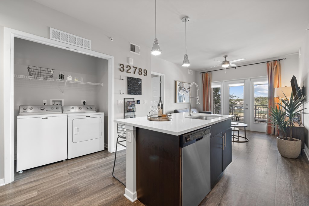 A modern kitchen with white appliances and a dark countertop.