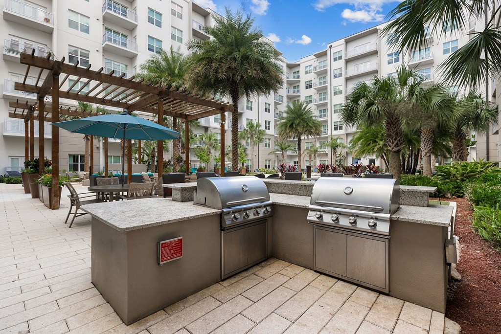 A large outdoor grill is in the middle of a patio.