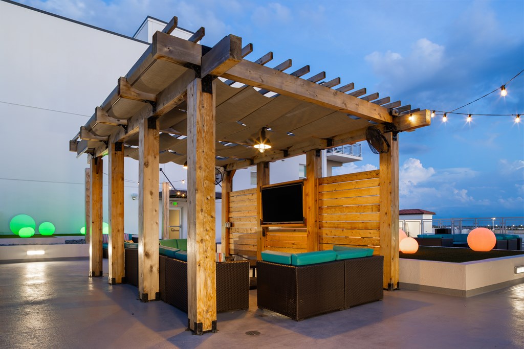 A wooden structure with a roof and a bench underneath it.