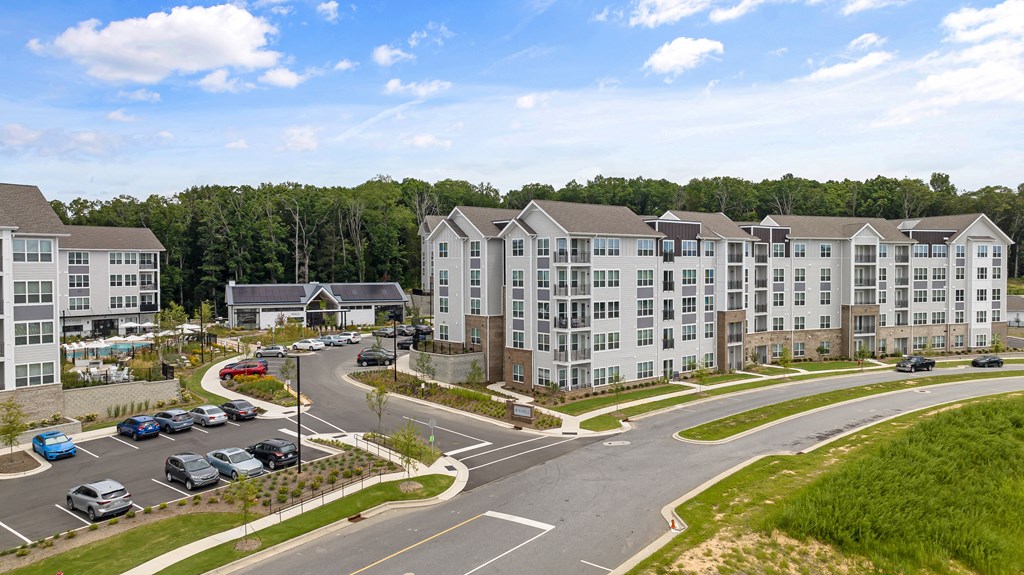 an aerial view of an apartment complex with a parking lot