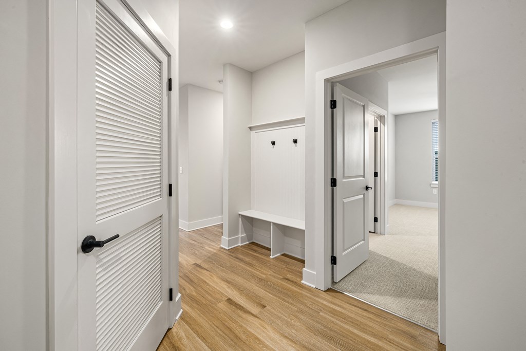 hallway with white walls and brown wooden floor