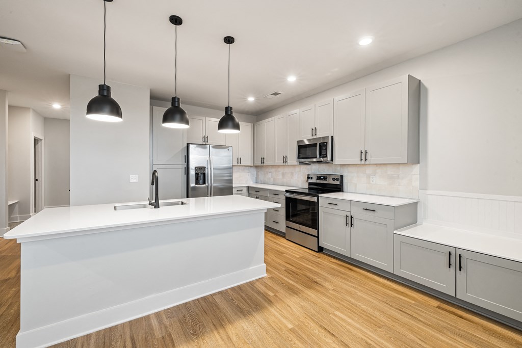 white kitchen with brown wooden floorsl