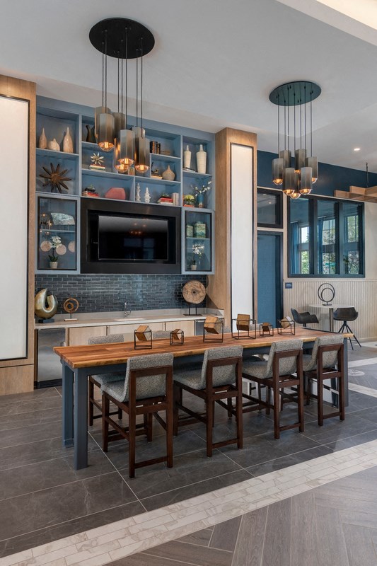 a dining room with a wooden table and chairs and a kitchen with a tv