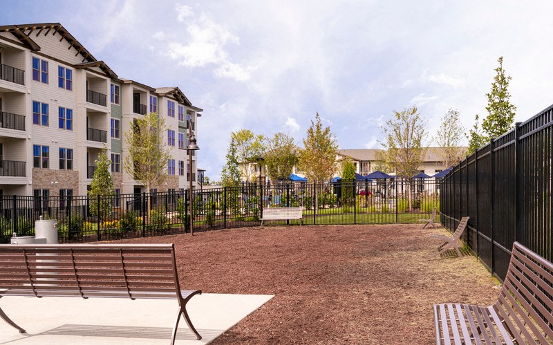 a park with benches in front of an apartment building