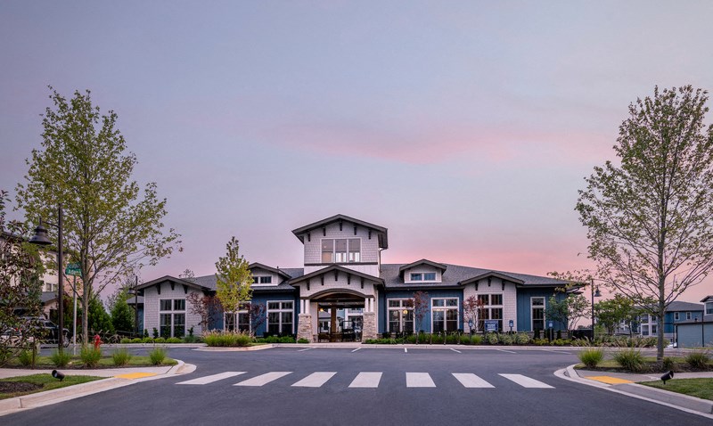 a building with a street in front of it and a pink sky