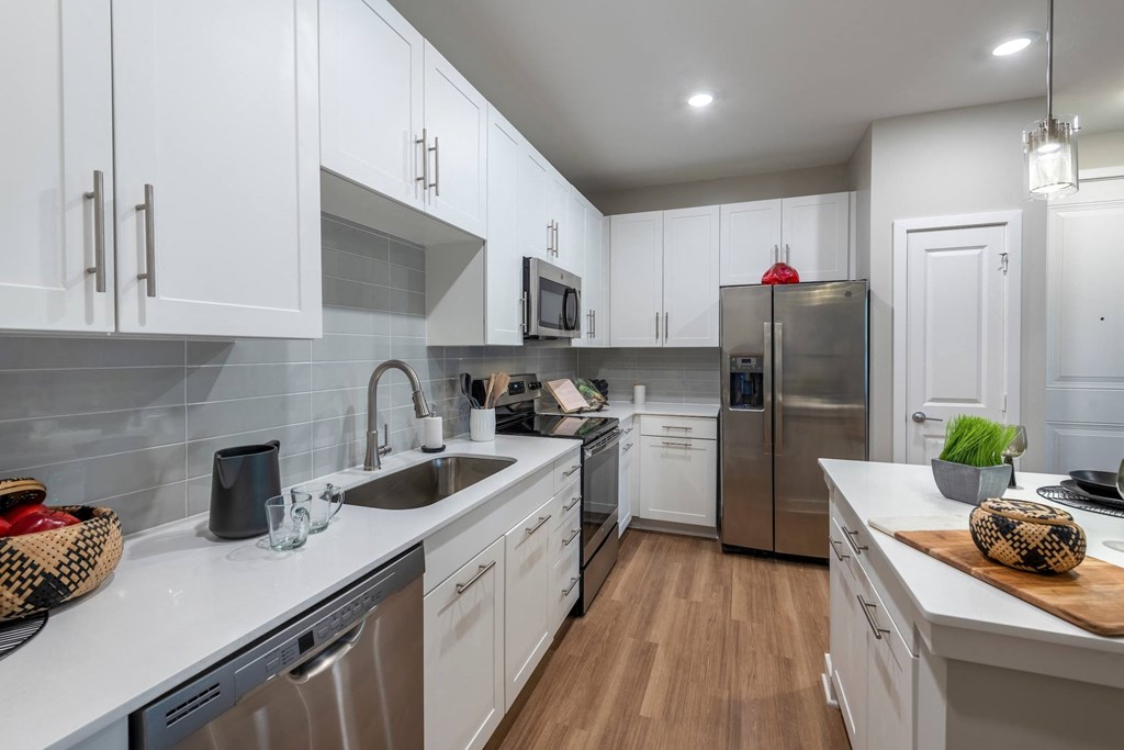 a kitchen with white cabinets and stainless steel appliances