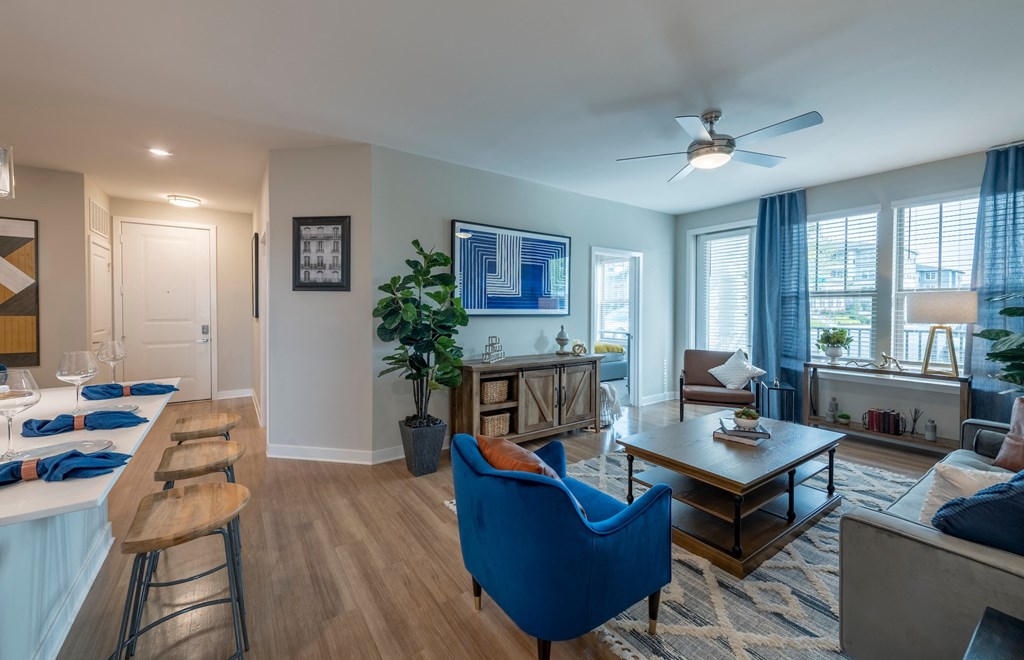a living room with blue furniture and a ceiling fan