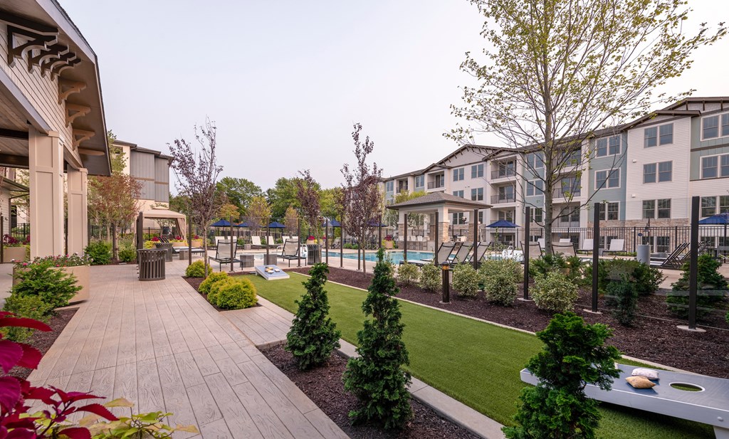 a courtyard with a pool and landscaping at the district at highland village apartments