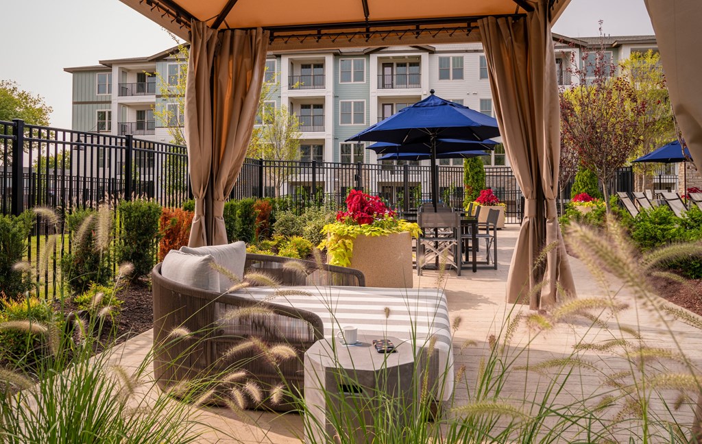 a patio with chairs and tables and umbrellas