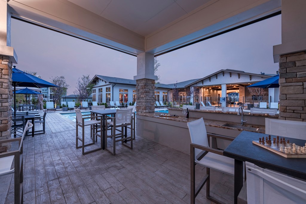 the retreat at thousand oaks clubhouse patio area with tables and chairs and a bar