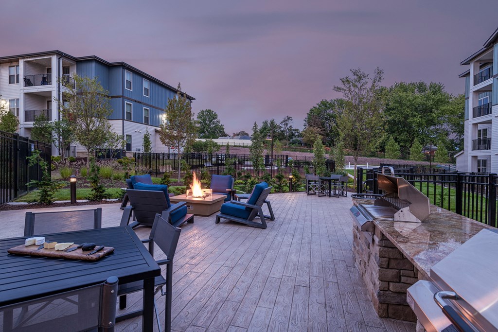 an outdoor patio with a fire pit and tables and chairs