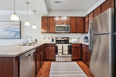 A modern kitchen with wooden cabinets and stainless steel appliances.