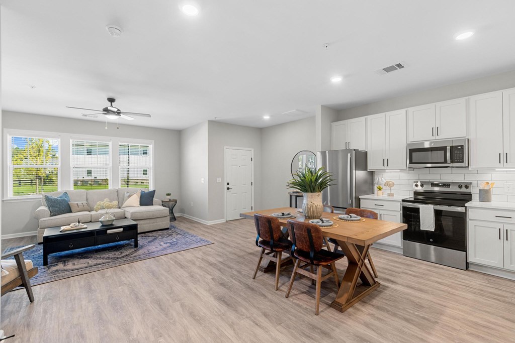 A modern kitchen with a dining table and chairs in the middle of the room.