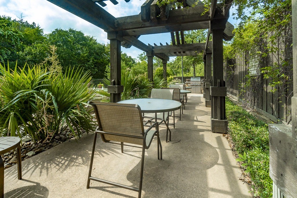 a patio with tables and chairs and a pergola