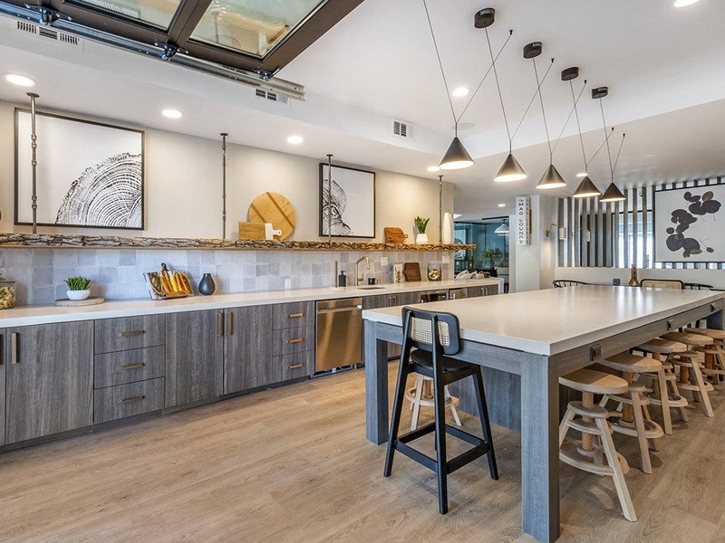 a large kitchen with a long counter and chairs
