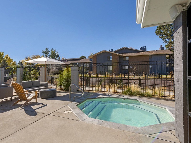 our apartments have a resort style pool with chairs and an umbrella