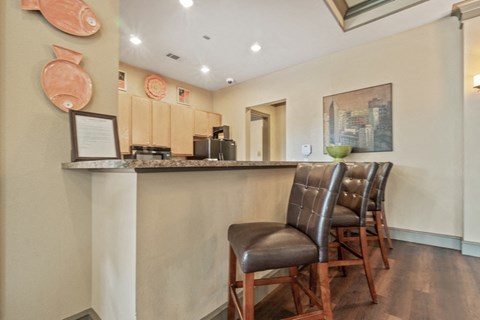 a bar area with leather chairs and a counter top in a kitchen