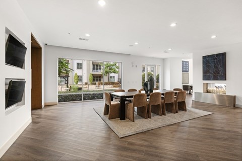 A modern dining room with a large table and chairs.