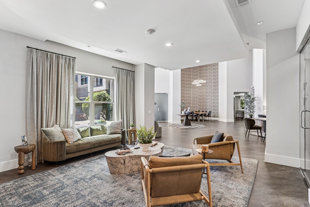 A living room with a couch, chairs, and a rug.