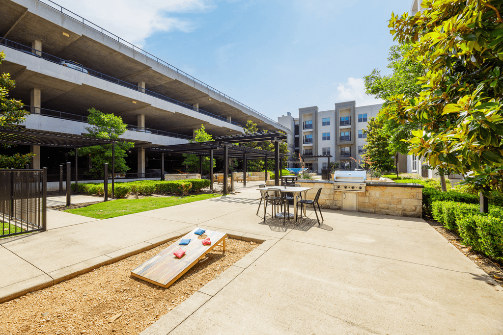 A playground area with a slide and a table set up outside a parking garage.