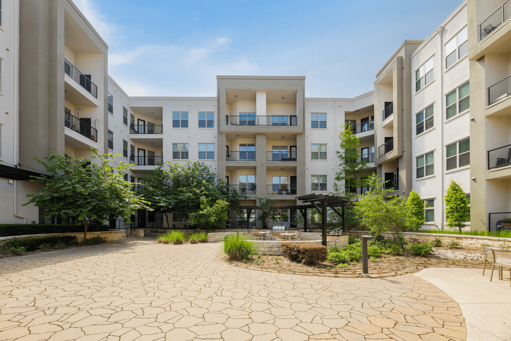 A courtyard with a circular patterned ground and a pavilion in the middle of the courtyard.