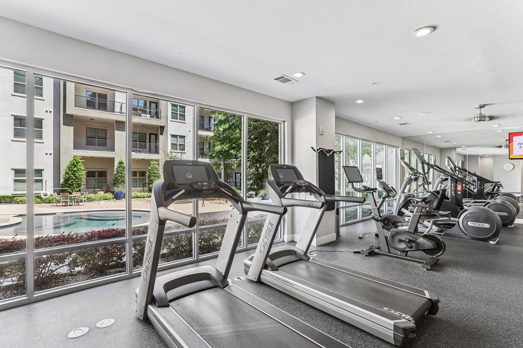 A gym with treadmills, exercise bikes, and other equipment.