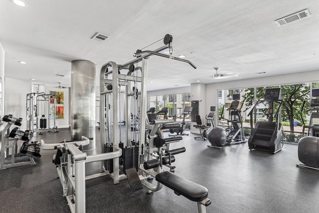 A gym with a variety of equipment including weights and cardio machines.